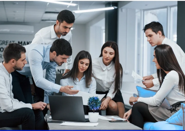 Group of diverse employees collaborating in a modern office, illustrating a strong company culture and employer brand.