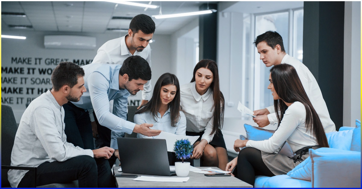 Group of diverse employees collaborating in a modern office, illustrating a strong company culture and employer brand.